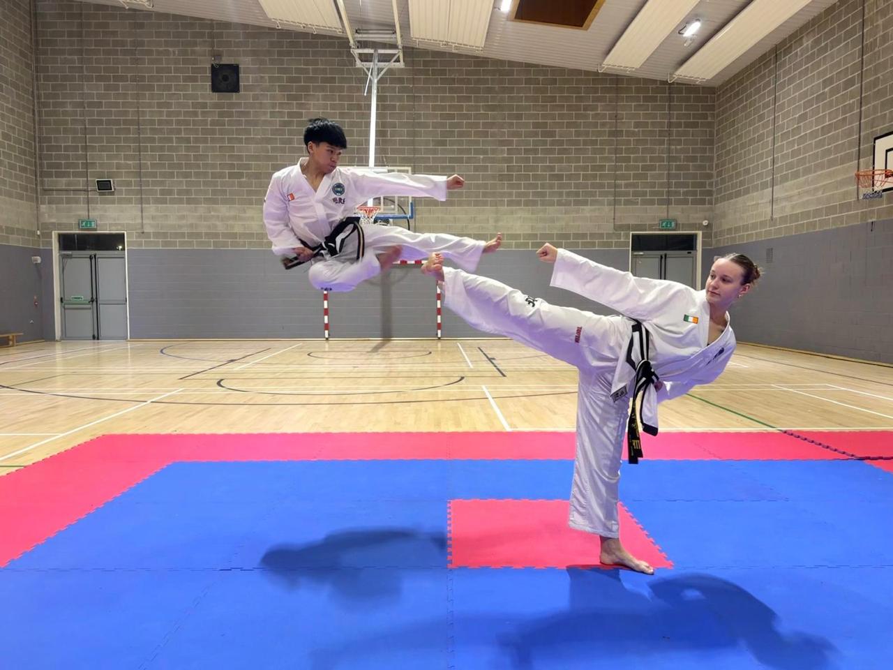 Two Sligo ITF black belts performing a flying kick and side kick in training